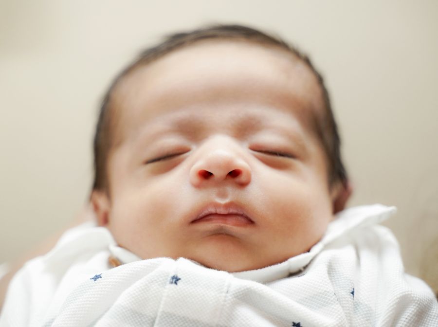 Sleeping newborn baby ready for an infant passport photo